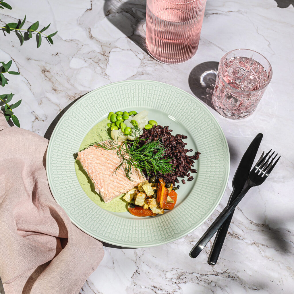Laxfilé, sauterade rotfrukter och kapris samt grön dillsås. Serveras med svart ris