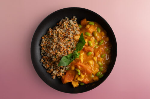 Tomatbaserad gryta med curry, tofu och mango serveras med röda linser
